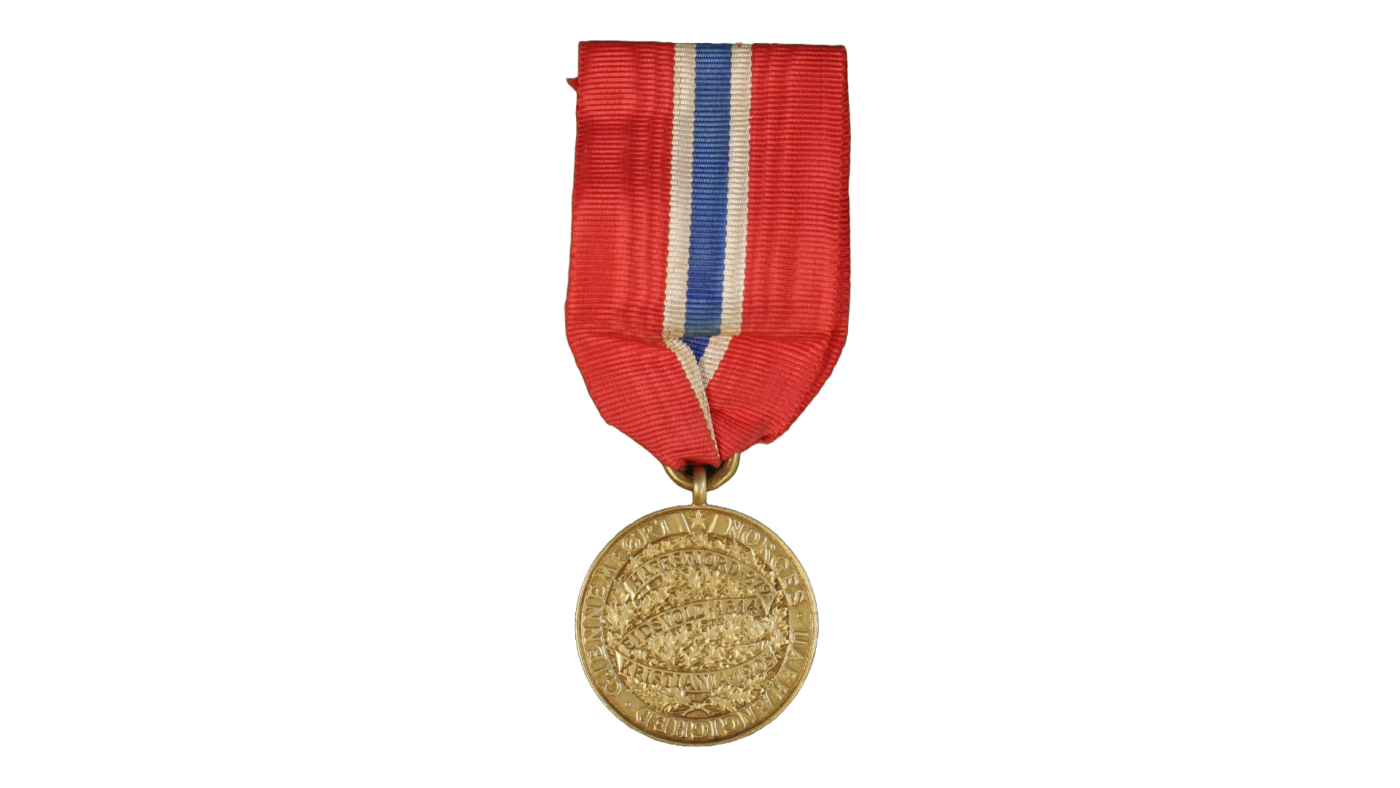 Bilde av medalje i gull med band i fargane til det norske flagget - raudt, kvitt og blått. 