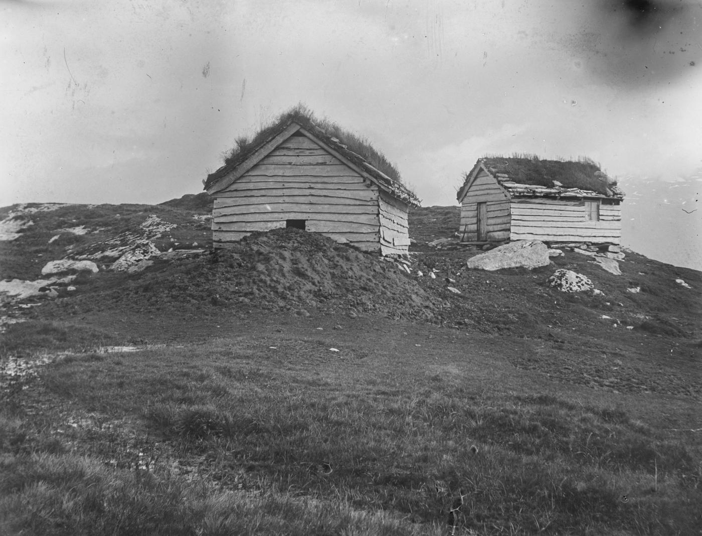 bilde i svart-kvitt av fleire eldre bygningar, støl