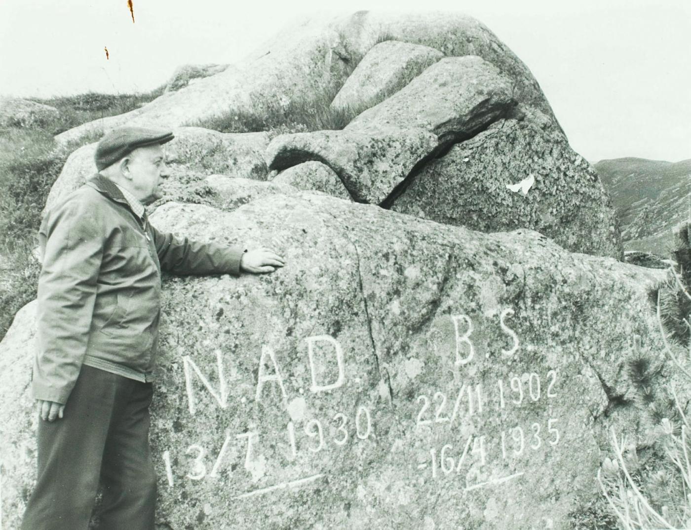 Minnestein med tekst på, mann med hatt