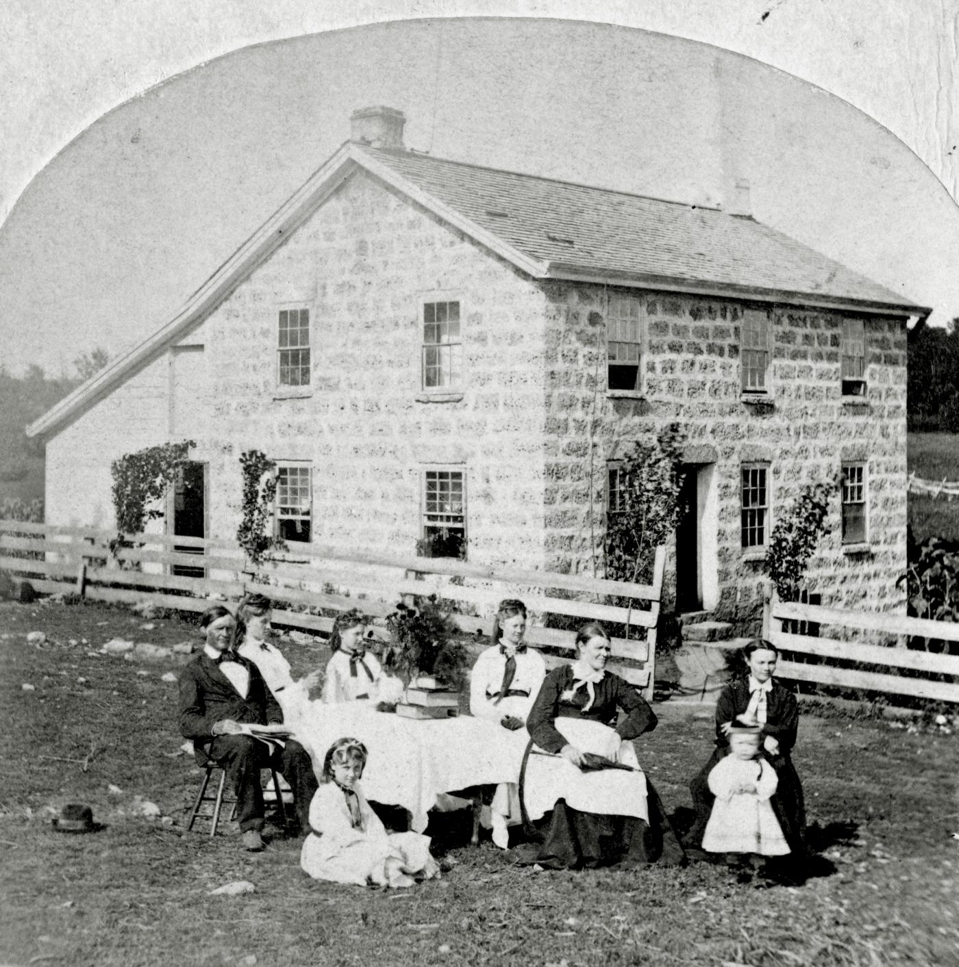 Familiegruppe framfor murhus.