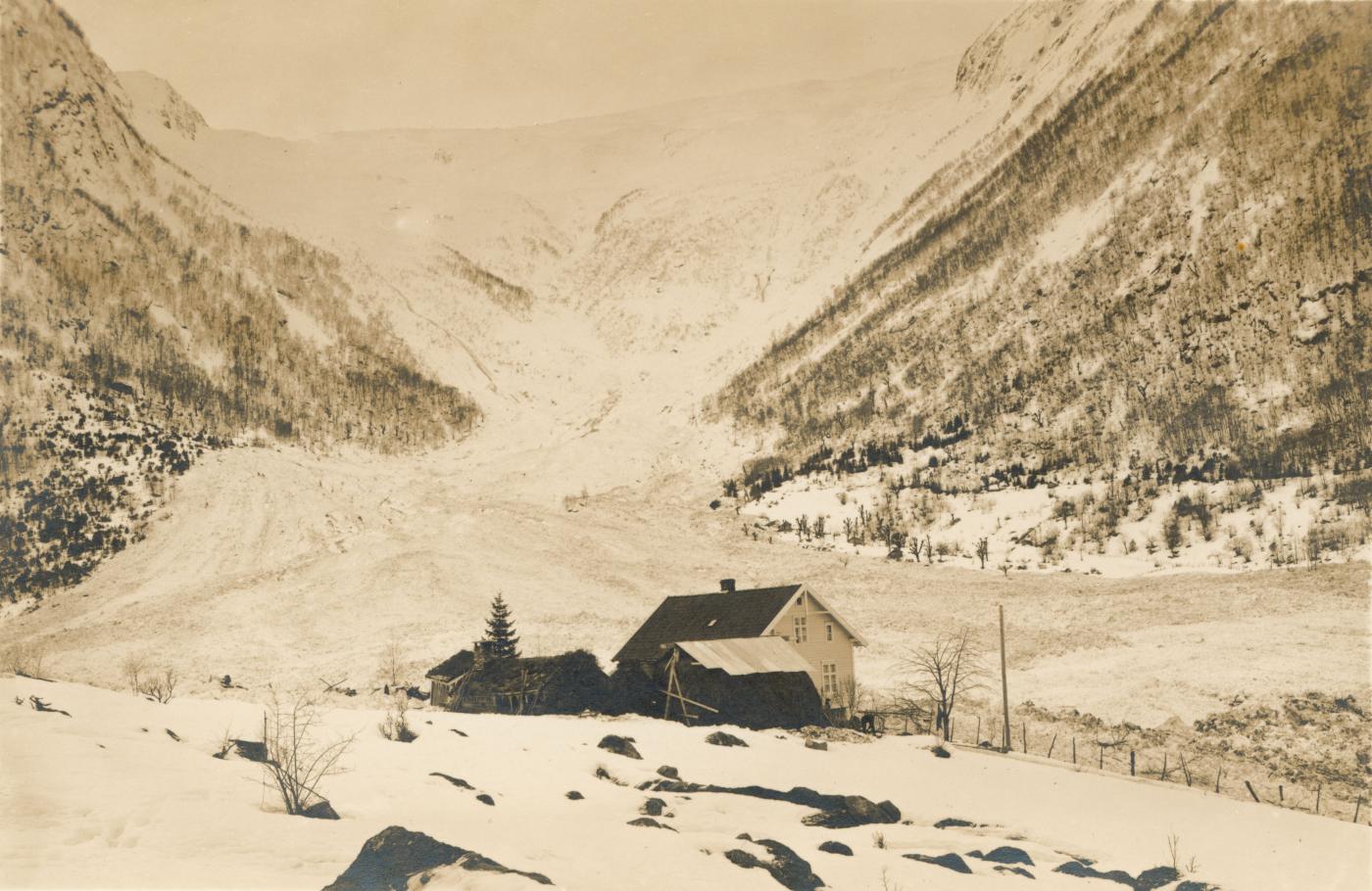 Bilete frå skreda i Ese i 1928 med husa på bruk nr. 1. Driftsbygningen vart teken av skreda. Dyr som vart skadde i skreda måtte naudslaktast og vart hengde opp i trea til høgre for husa. Biletet gjev eit godt inntrykk av kor enorme snømassar som kom ned frå fjellet. Dalføret vidare nedover til høgre for husa vart heilt oppfylt av snømassane.