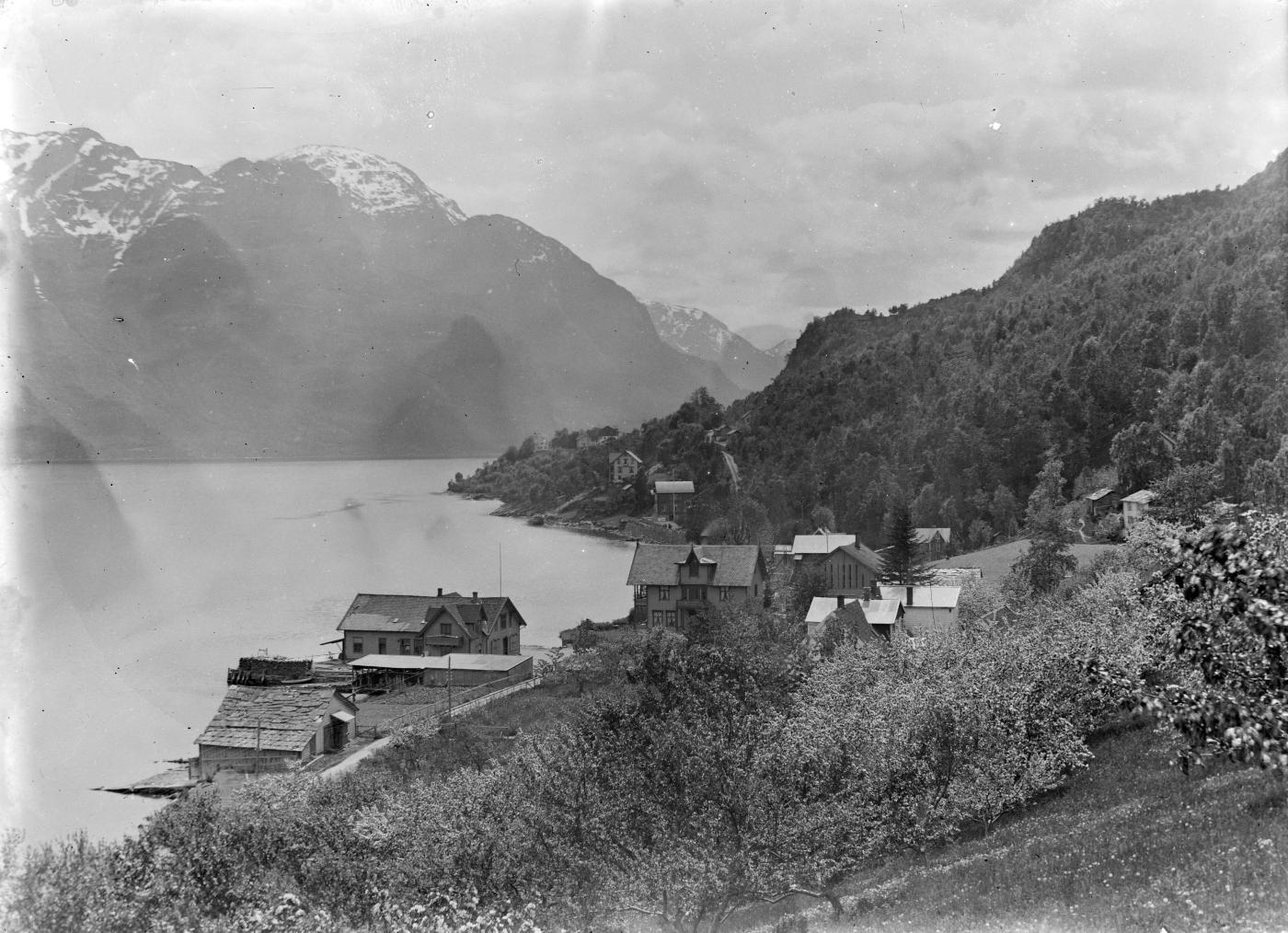 Døsen i Luster. Tingstova ligg til venstre, nesten i sjøkanten, og hovudbygningen til høgre. Biletet er teke ovanifrå og ut fjorden. Sørheimsfjell i bakgrunnen.