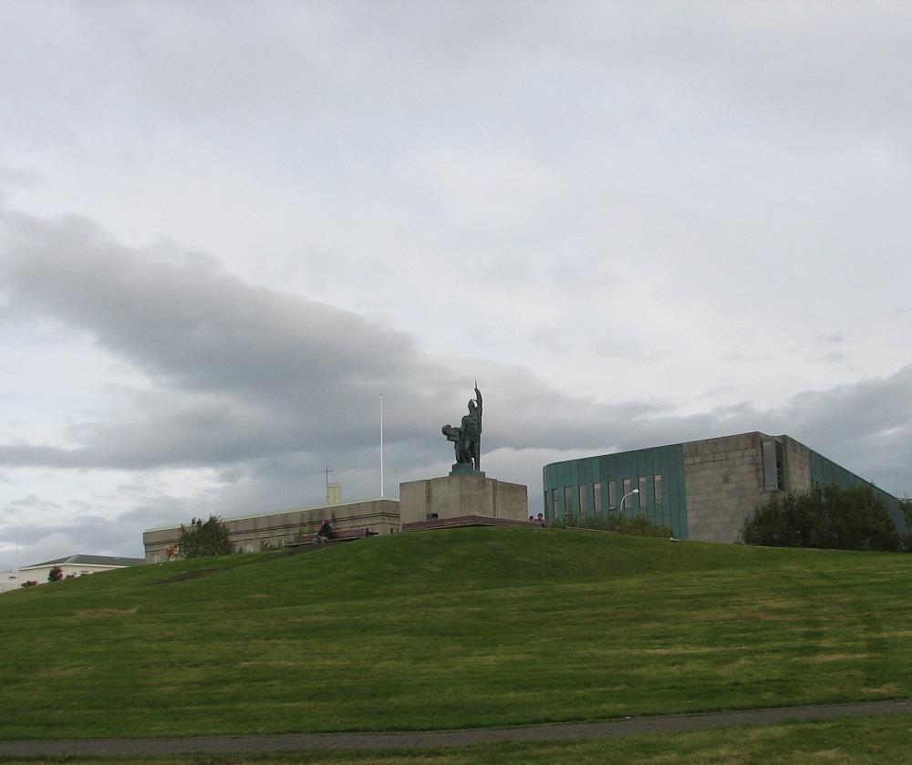 Ingolv Arnarson-minnesmerket på Arnarholt i Reykjavik. Bygningane i bakgrunnen høyrer til universitetet.