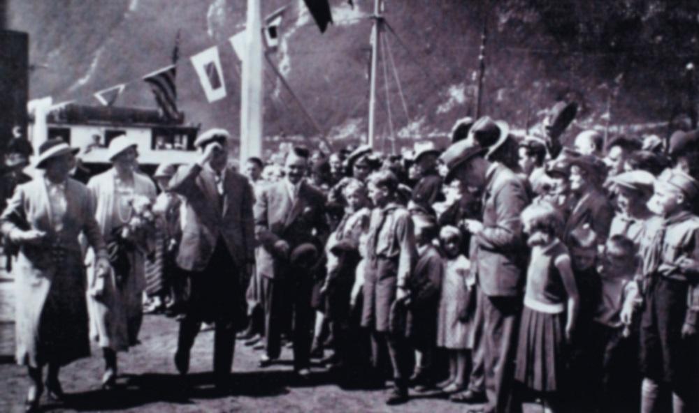 Kronprinsparet i Høyanger, pinsehelga 1933. Flaggsmykka MS "Nesøy" ligg til kai.