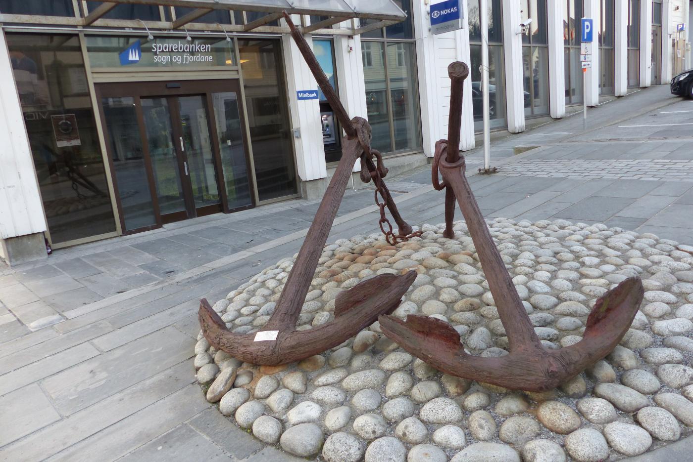 Skipsankera i Torggata i Florø, utafor hovudinngangen til Sparebanken Sogn og Fjordane. Kvart anker har legg (lengde) på 2,3 meter. Fundamentet er laga av rullesteinar frå Berle på Bremangerlandet.