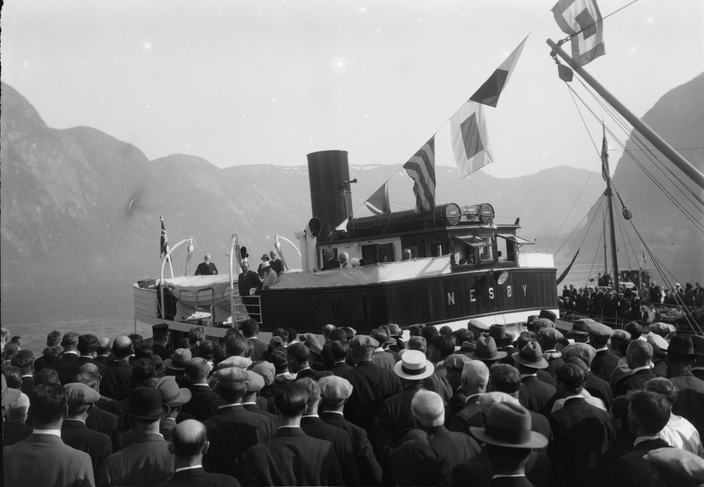 MS «Nesøy» som «kongeskip» til kai i Høyanger, 2. pinsedag 1933. Nybygde «Nesøy» tok kronprinsparet, kronprins Olav og kronprinsesse Martha, gjennom fylket på to strekningar, først Olden – Sandane, så Vadheim – Lærdal.