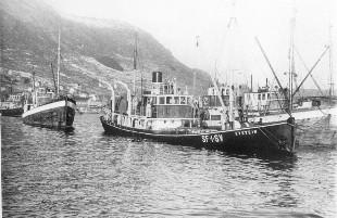 Sildesnurparen "Eystein" (Gamle-Svarten) vinteren 1954 fullasta med sild på Måløy hamn "med nasen såvidt over vatnet", -  ventar på å få levere. 

