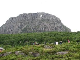 <p>Risneshaugane med Risnesnipa i bakgrunnen. Risnesnipa er ein del av fjellmassivet som g&aring;r under namnet Lihesten. &quot;Hav&oslash;rn&quot; flaug inn i fjellveggen. Biletet vart teke 14. juni 2008 d&aring; minnesmerket om ulukka vart avduka.r. Krossen syner kvar flyet traff fjellet.</p>