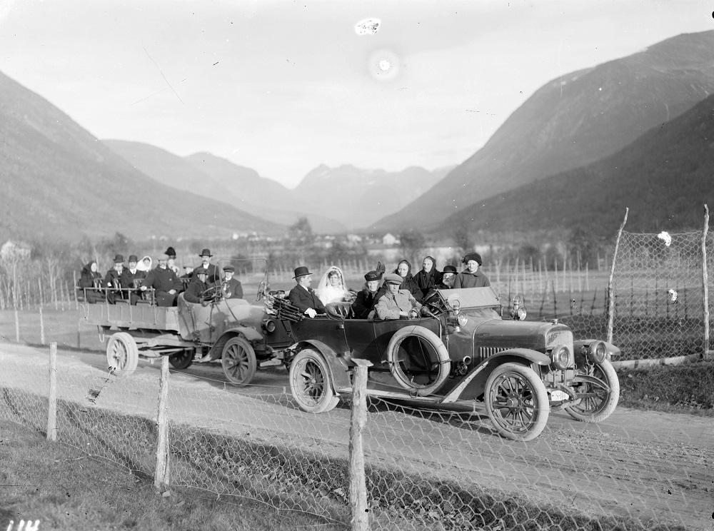 Dette er to av dei første bilane til Nordfjord og Sunnmøre billag. Bilen til venstre er ein Opel kombinertbil. Bilen til høgre er ein sjuseters Adler. Biletet er teke 12. oktober 1915. Olav Osnes frå Nordfjordeid og Jenny Aarnes, Stryn, hadde nettopp gifta seg i Nedstryn kyrkje.

 