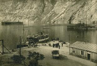 <p>Biletet med MS &laquo;Sand&oslash;y&raquo; til kai i L&aelig;rdal og tre krigsskip til ankers&nbsp;p&aring; fjorden. P&aring; baksida av originalfotoet st&aring;r notert: &laquo;Sand&oslash;y ved Hammerfest med f&aelig;rge og krigsskibe i Norge (krigstid 1940-1945)&raquo; Det er sett pil mellom Sand&oslash;y og f&aelig;rge.</p>