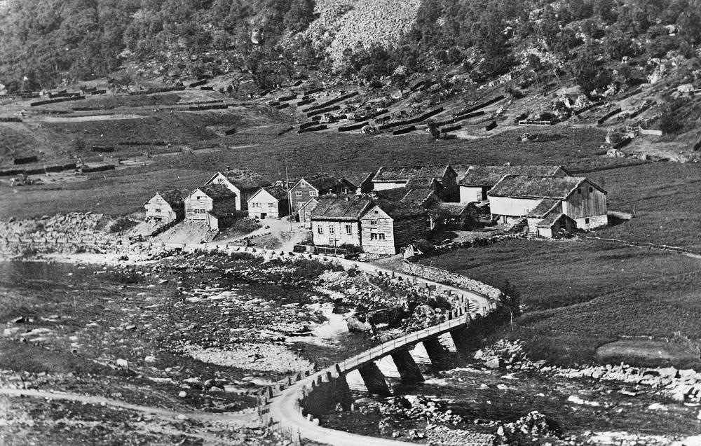 Det gamle klyngetunet for fem gardsbruk på Ommedal rundt 1912. Brua på bygdevegen i framgrunnen stod ferdig i 1894/95.  

 