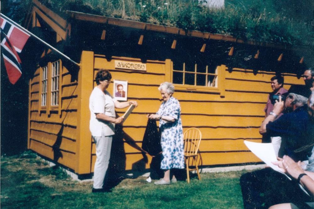 Jakobsbu på Hogrenningssætra. Jenny Drage, eldste syster til bonde og patentførar Jakob Hogrenning, og mora Laura, avduka skiltet på det nydøypte huset, Jakobsbu.
