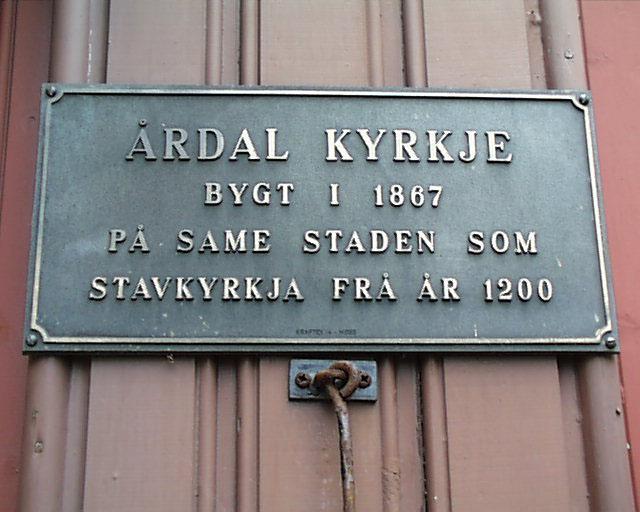 Til høgre for inngangsdøra heng dette skiltet som fortel at kyrkja er bygd på same staden som stavkyrkja frå 1200-talet.
