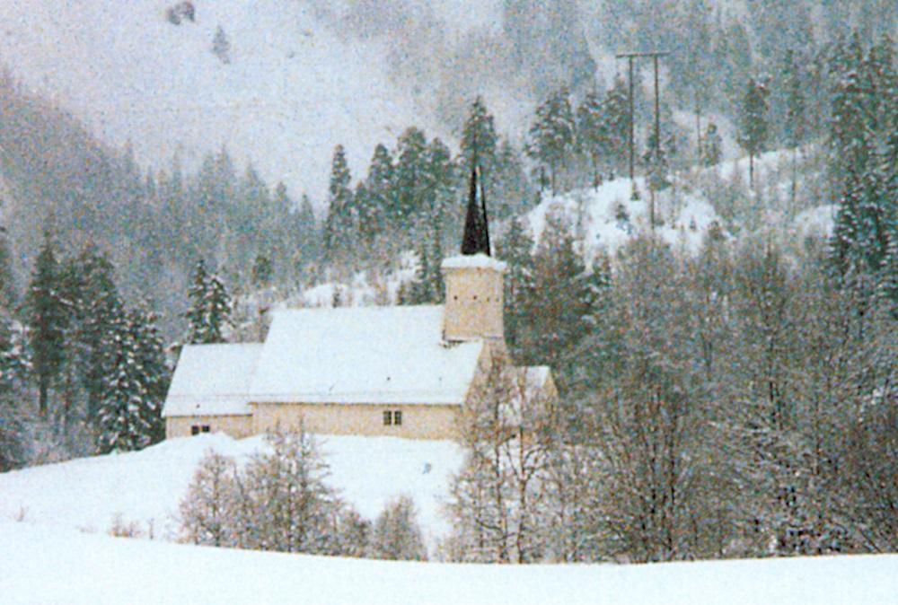 Den vesle, gamle tømmerkyrkja er innramma av ein mektig natur. Dei to tidlegare kyrkjene stod truleg like i nærleiken.
