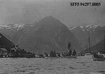 Balestrand den 13. august 1905: Mange menneske er samla på fjorden i samband med folkerøystinga i Tjugum kyrkje der ein skulle seia ja eller nei til unionen. Robåtane er fulle av festkledde kvinner og menn. 