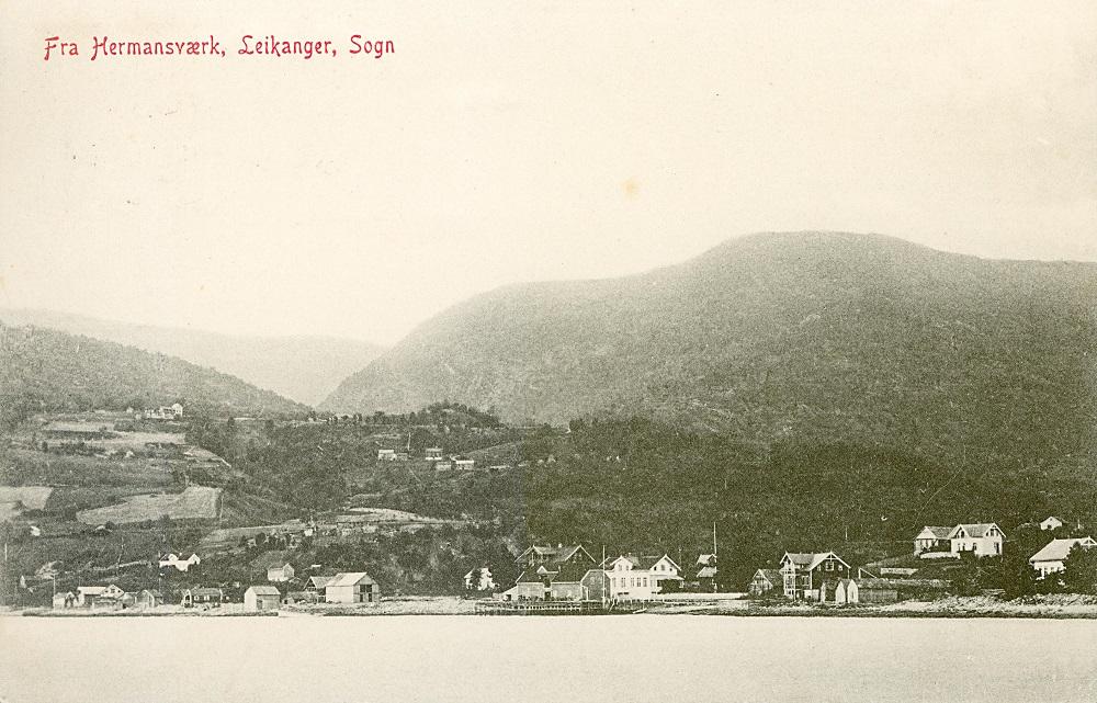 Hermansverk kring 1908. Huset med ark ved sjøen, Knudsen-huset, står enno. Det kvite midt på gjekk under namnet Borch-huset og Torp-huset, etter amtsingeniørar som budde der. Det stod der det er park no. Til venstre for Torphuset syner det som i dag vert kalla Gamle-Hotellet. Nedanfor er Knudsenbui og dampskipskai. På Henjasanden, lenger til venstre på biletet, dreiv dei med båtbygging.
 


