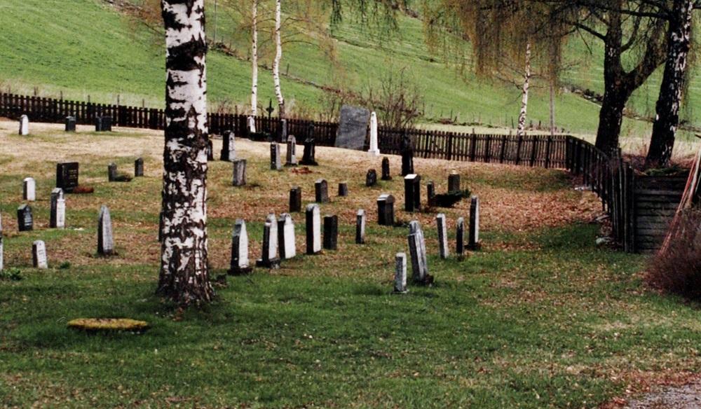 Aust på kyrkjegarden ved Fet kyrkje står eit uvanleg gravminne. Det er ei svær firkanta helle med skrift og figurar. Gravminnet har vore flytta fleire gonger frå ho opphavleg var plassert på grava til "Gaardmand Jakob Trondsen Fedt", fødd 1810, død 1858.