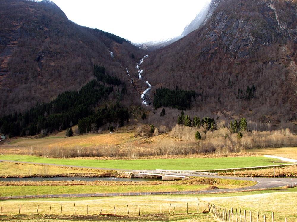 Utsyn mot Eiki og Eikjadalen frå Ulvestad. Svære mengder grus og stein har opp gjennom tidene kome ned frå Eikjadalen i skreder. Etter skredene i 1868 og 1877 vart gardstunet som før låg på Storåkerhaugen i rasområdet delt og bygd opp att sør og nord om rasområdet. Eikjadalen er ein typisk hengjande u-dal.