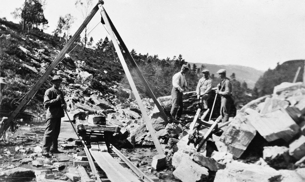 Frå vegarbeid i øvre Lavikdalen i byrjinga av 1930-åra. Dei brukte steinbukk for å løfta steinar dei ikkje greidde med handemakt opp på ein vagg som gjekk på skjener til tipplassen. 

 