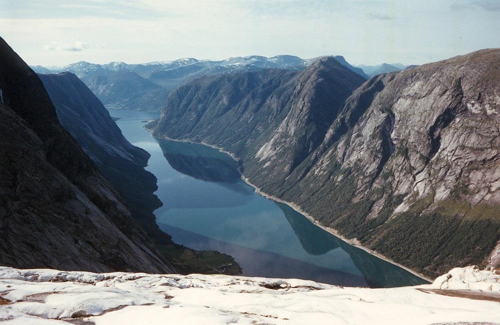 Det er vilt og bratt langs den vakre Kjøsnesfjorden.  Her ser vi det meste av strekninga mellom Kjøsnes og Lunde. Høge skjeringar, mange tunnelar og rasoverbygg fortel at terrenget ikkje er det lettaste å byggja veg i.