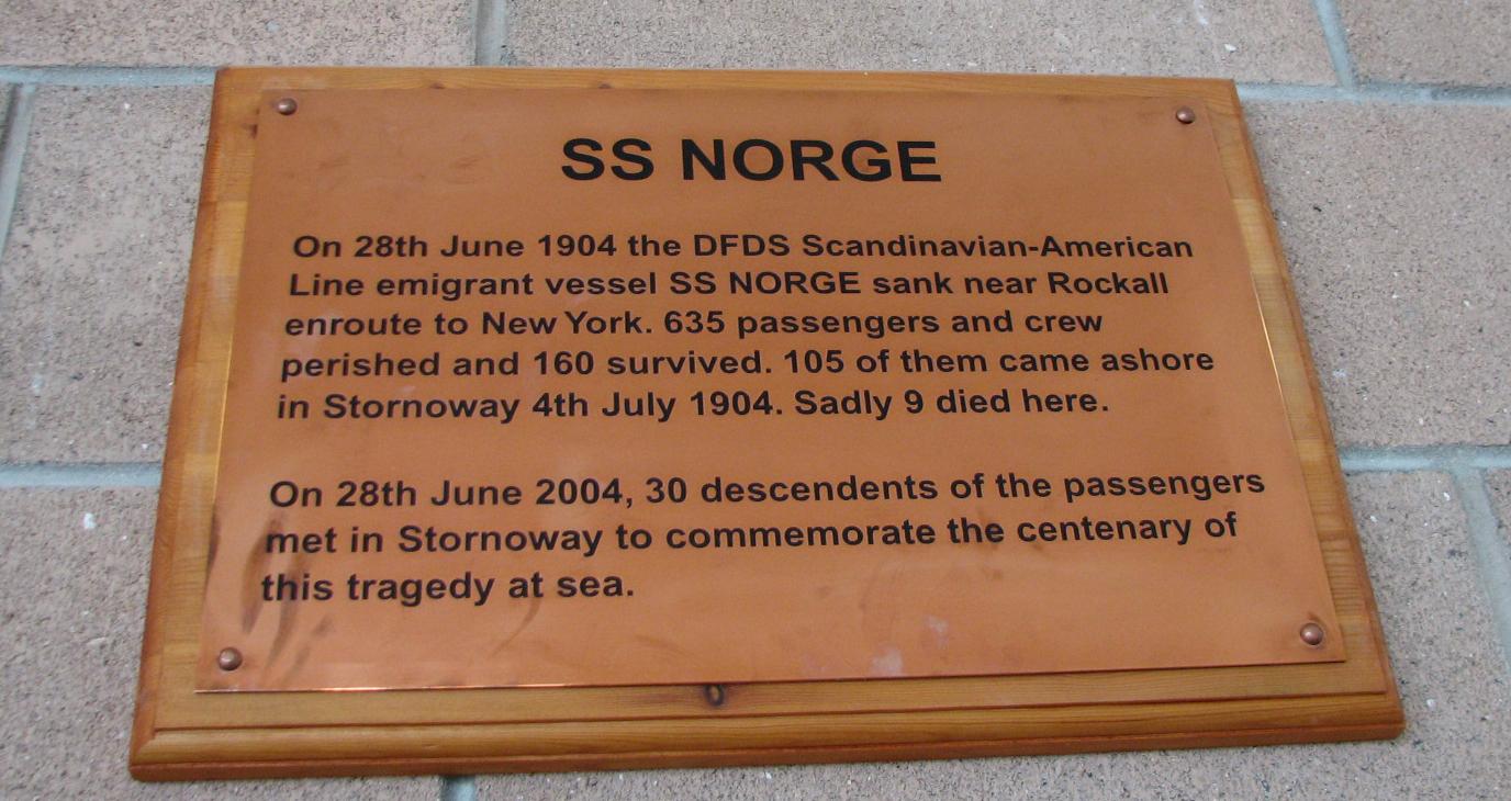 Minneplaketten om <i>Norge</i>-forliset, avduka i Stornoway, 28. juni 2004. I norsk omsetjing står: Den 28. juni 1904 gjekk DFDS Skandinavien-Amerika-Linjen sitt emigrantskip SS NORGE ned nær Rockall på veg til New York. 635 passasjerar og mannskap omkom og 160 overlevde. 105 av dei kom i land i Stornoway 4. juli 1904. Uheldigvis døydde 9 her. Den 28. juni 2004 møttest 30 etterkomarar av passasjerane i Stornoway for å markera hundreåret for denne tragedien til sjøs.