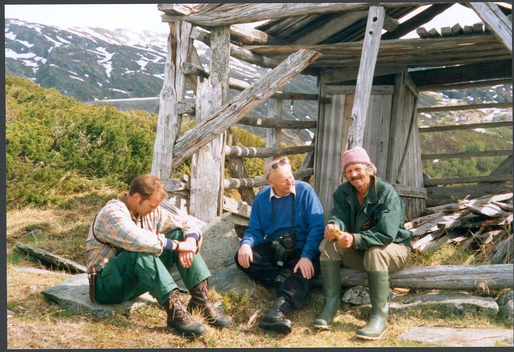 Tre karar på synfaring i samband med å ta vare på dei gamle torvhusa på stølen Ringane ved Turtagrø, Oddmund Klakegg (naturforvaltaren i Luster kommune), Sverre Bolstad og Sverre Yttri. Her sit dei attmed eit torvhus av "nyare" dato.