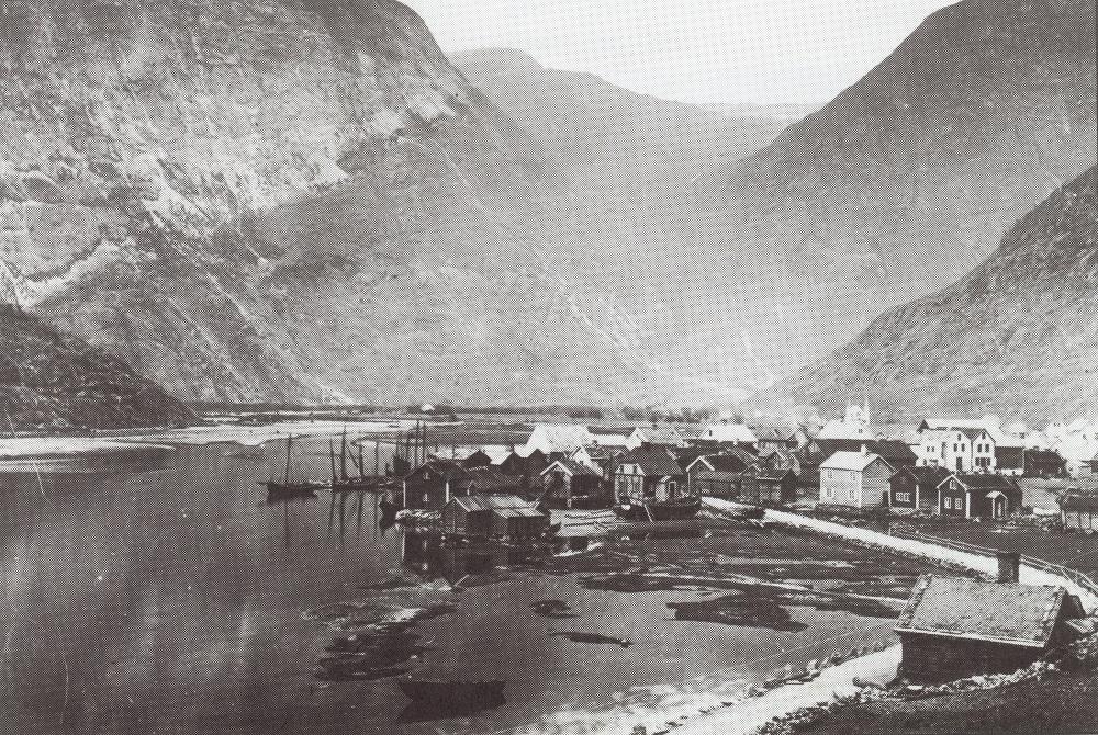 Lærdalsøyri voks fram på ein allmenning ved Lærdalselvi sitt utløp i fjorden. Biletet syner Lærdalsøyri kring 1880. Fremst ser ein Lågøyna. På Løytnantsbryggja ligg det fleire jekter. Krambuene til handelsmennene finst lenger til høgre på biletet. I bakgrunnen skimtar ein den nye kyrkja, ferdig i 1869. Lengst bak ligg Hansegarden, der kjøpmann Jan Henrik Nitter Hanssen budde.