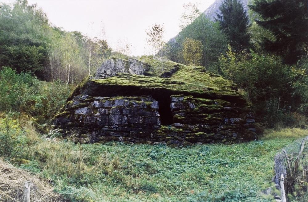 Ein overhendig stor stein har ein gong i farne tider rasa ned på Helset og lagt seg til tett ovanom vegen inn langs Lovatnet. Eit utspring (overheng) på steinen på nedsida dannar ein stor hedler. Ved å laga mur, fekk dei seg eit godt "uthus" på garden, i si tid nytta som krypinn for utegris. Opningen i muren gav godt dagslys inne.