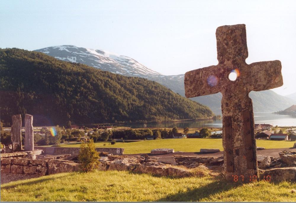 Steinkrossen i Loen står tett innom kyrkjegardsmuren ved den opne plassen framfor kyrkja. 
