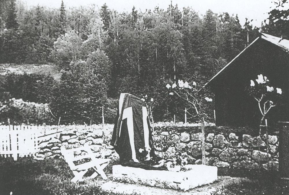 Minnesteinen på grava til Johan A. Berge, sveipa i det norske flagget før avdukinga.