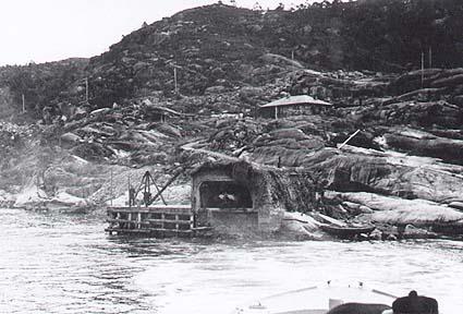 Den tyske marinen hadde ferdig torpedo-batteriet i Rutledal alt i mai 1940. Mannskapet budde i brakka vi ser ovanfor torpedo-bygningen nede ved sjøen. Bortover knausane til høgre på biletet låg kystfortet.<br />