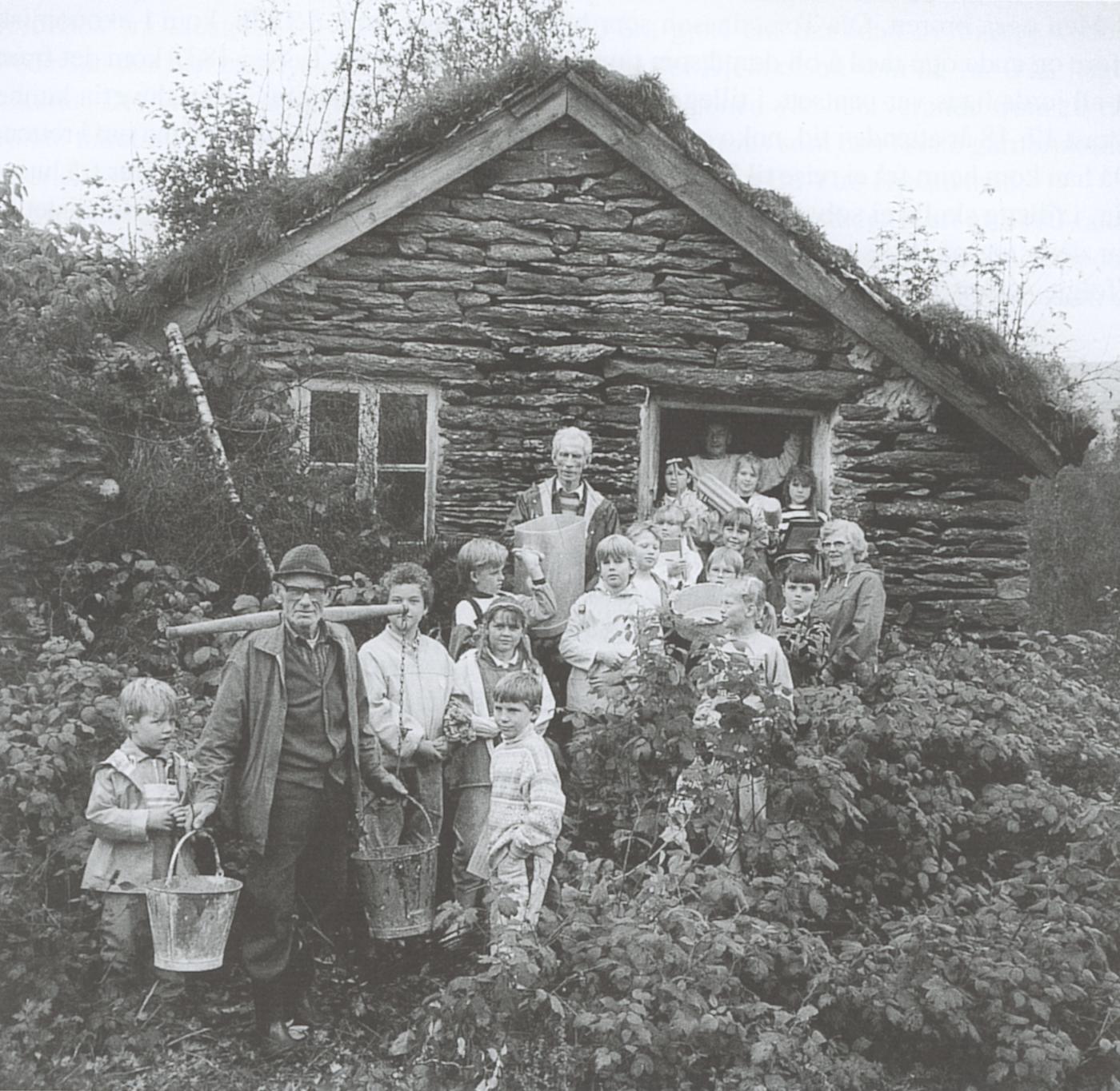 Hausten 1988 var ein fjerdeklasse på besøk i det gamle meieriet på Hjelmeland. Elevane fekk omvising av folk som hadde vore med då meieriet var i drift. Heilt fremst står Hermann Fauske som hadde med seg barnebarnet Vegard Gillestad. I midten til venstre står Ingvar Fauske og til høgre Målfrid Åse som var meierske her. I døropninga kan vi skimte Albert Hjelmeland. Avisa Firda var til stades og laga ein reportasje om hendinga, og det var journalisten som tok biletet.
