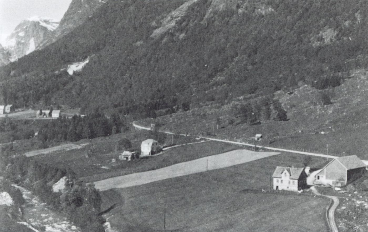 Flyfoto av dei fremste bruka på Langeteig. Elva renn like ved garden, og flaumen øydelagde i alt 35 mål åker og slåttemark på Langeteig 
