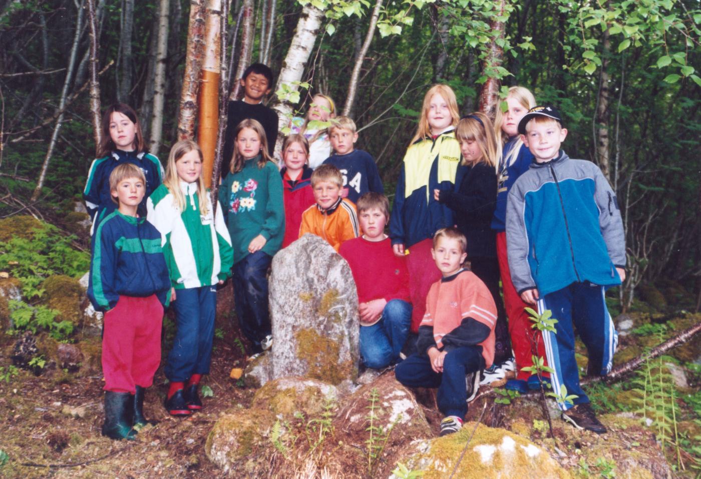 Elevane ved Fresvik skule som hadde uteskule ein dag i veka skuleåret 2000/2001. Her er dei samla ved den nedramla minnesteinen dei fann og seinare var med og sette opp att på den opphavlege staden.