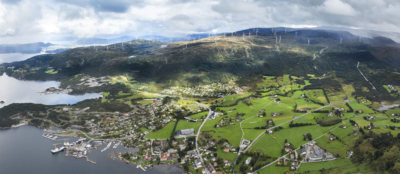 Vindkraftanlegget på Midtfjellet med bygda Fitjar i framgrunnen.