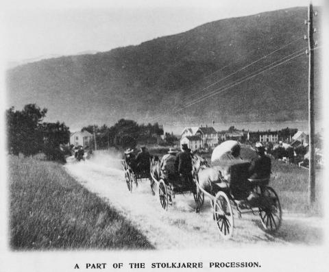 "A part of the stolkjarre procession". Stolkjerrer med turistar på veg nedover ein ukjend veg.