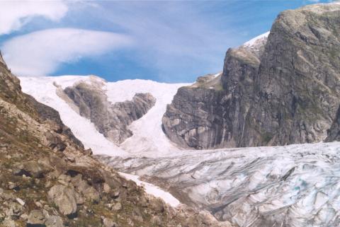 Utsyn mot to av to av brearmane som fører ned til Austerdalsbreen inst i Austerdalen. Den tredje, som ikkje heng saman med breen nede i dalen, ligg til venstre for desse. Breane har namna Lokebreen, Odinbreen og Torsbreen, rekna frå aust (frå høgre på biletet). Slingsby-ekspedisjonen tok seg opp fjellpartiet midt i, same vegen som ruta går no. På toppen står Kvitesteinvarden, varden som Kristian Bing bygde i 1894.