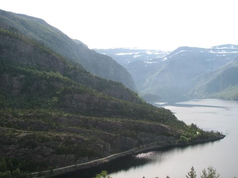 Risevatnet ved Svelgen med utsyn austover. Tåhammarfjellet går bratt opp frå vatnet på nordsida, innom neset i framgrunnen.