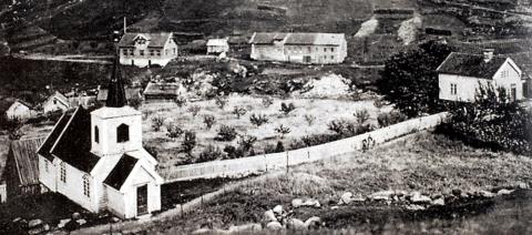 Stavkyrkja og Kyrkjeaokkeren sett mot søraust, kring 1920. Til høgre ligg den gamle lensmannsstova og i bakgrunnen ser vi Nigarden.