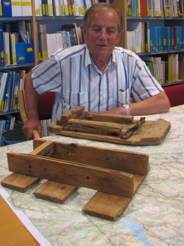 Bjarne Haugnes, fødd 1930, frå Florø, på Fylkesarkivet, juli 2008. Han har samla opplysningar om flukta og fluktruta til dei engelske soldatane våren 1940. Her har han heimelaga truger soldatane la att då dei var i Vigdal. Den fremste ligg opp ned. Peder Vigdal meinte dei var heilt ubrukelege. Gudrun Vigdal, Luster, eig trugene.