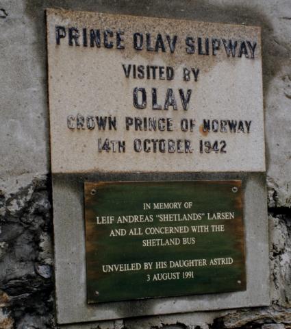 Minneplate om kronprins Olav sitt besøk hjå Shetlandsgjengen (The Shetland Bus) i Scalloway 14. oktober 1942. Slippen fekk etterpå namnet Prince Olav Slipway. I 1991 vart det sett opp ein plakett til minne om Leif Andreas Larsen (Shetlands-Larsen), den best kjende skipperen, og alle dei andre som var med i The Shetland Bus.