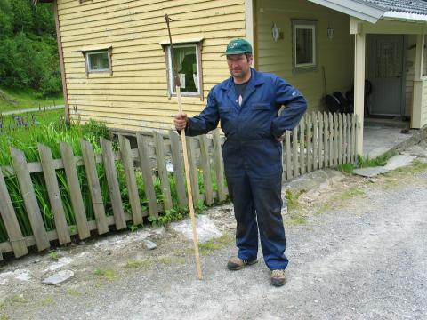 Hallvard Mulen med niseharpunen på eit skaft. Den gule fargen på husveggen til venstre er heimeprodusert kvaloljemaling frå lenge før krigen. Borda er osp.