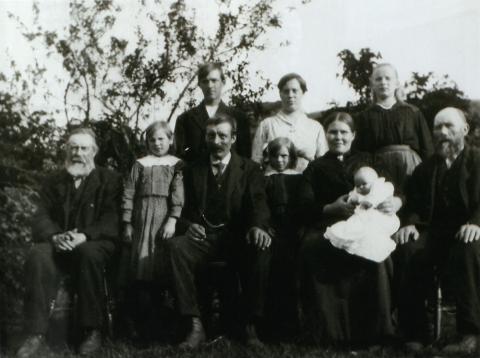 Familiesamling på Midtbø sommaren 1921, eit halvt år før brannen. Framme frå venstre: Lars Lågeide (far til Jonas), Jenny (omkom), Jonas (omkom), Ida (omkom), Anna med Ragna på fanget (begge omkom), Rasmus (far til Anna) (omkom). Bak frå venstre: Leonard (overlevde), Eline Skarstein (tenestejente), Alma Midtbø (overlevde).