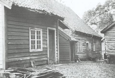 Baksida av våningshuset synte tydeleg at huset hadde vorte påbygd fleire gonger. Heilt til høgre ser me stabburet, og mellom våningshuset og stabburet ser me litt av skjenkestova.
