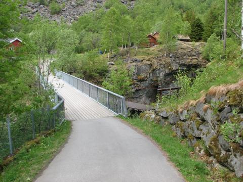 Skårabrui den første av fire bruer. Ei tidlegare hengebru er der framleis. På andre sida viser litt av anlegget Utladalen Naturhus.