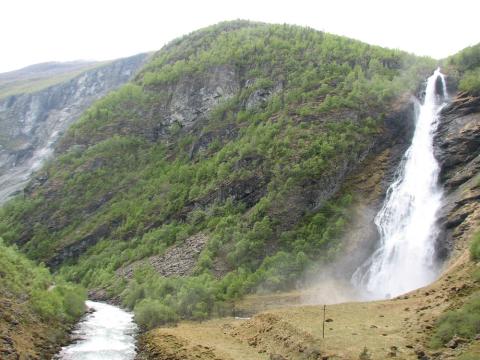 Avdalsfossen. Garden Avdalen ligg heilt oppe og på nordsida av fossen/elva (til høgre). Tidlegare tok folks eg fram ned berget sør for fossen.