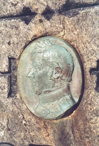 <p>Medaljong p&aring; minnesteinen over eidsvollmannen Ole Elias Holck. Han er laga av modell&oslash;r Torvald Olsen, Bergen, etter eit silhuettbilete av generalmajor Holck.&nbsp;</p>