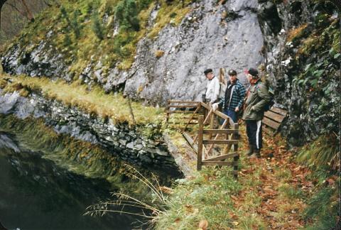 Den gamle postvegen er svært smal, og går her langs fjellskråninga heilt nede ved sjøen. Her er det sett opp ei bru. Brua går over eit svingparti på vegen inn mot Galdsviki. Vi ser korleis vegen er murt opp på det bratte svaberget som går rett i fjorden. 

