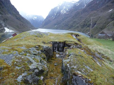 Krigsminna slik dei ligg i dag på Ramsøy med god utsikt både nordover Nærøyfjorden og innover til kaia i Gudvangen.