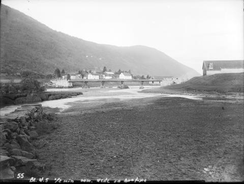 Den nye brua over Os i Nordfjordeid etter 1902. Biskop J. Neumann fortel i 1824 dette om vegen mellom Nordfjordeid og Hornindalsvatnet. 'En stor Slette udbreder sig fra Stranden af og langt op gjennem Dalen. Her ligger en herlig Landevei, og en paa samme anlagt stor og velbygt Bro fører over den mægtige Eids-Elv, der fra Horningdals-Vandet af slynger sig en heel Miil med strid Strøm ned igjennem Dalen.'

 